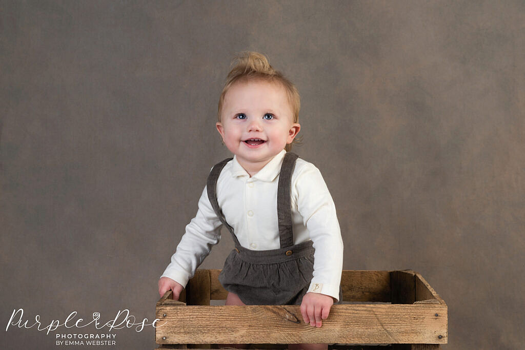 Child stood in a crate laughing