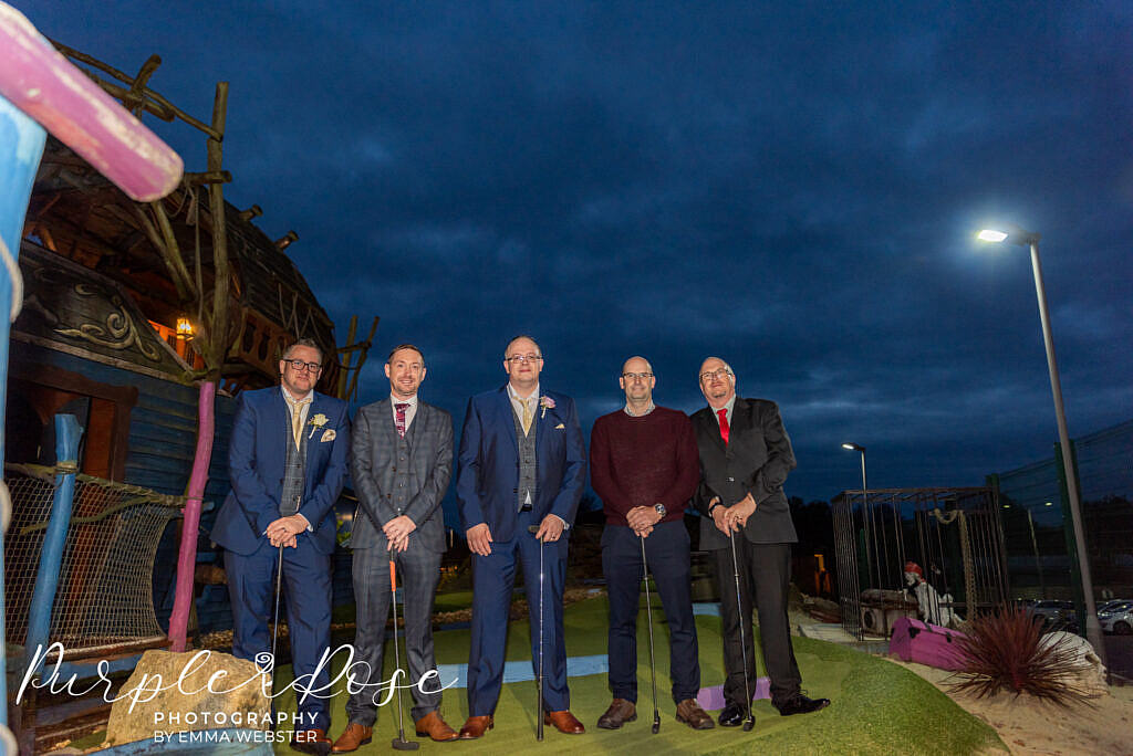 Groomsmen playing mini golf