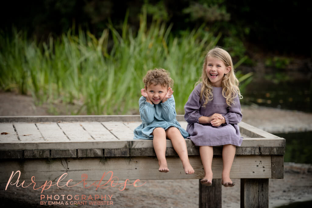 Sisters sat laughing on a fishing platform
