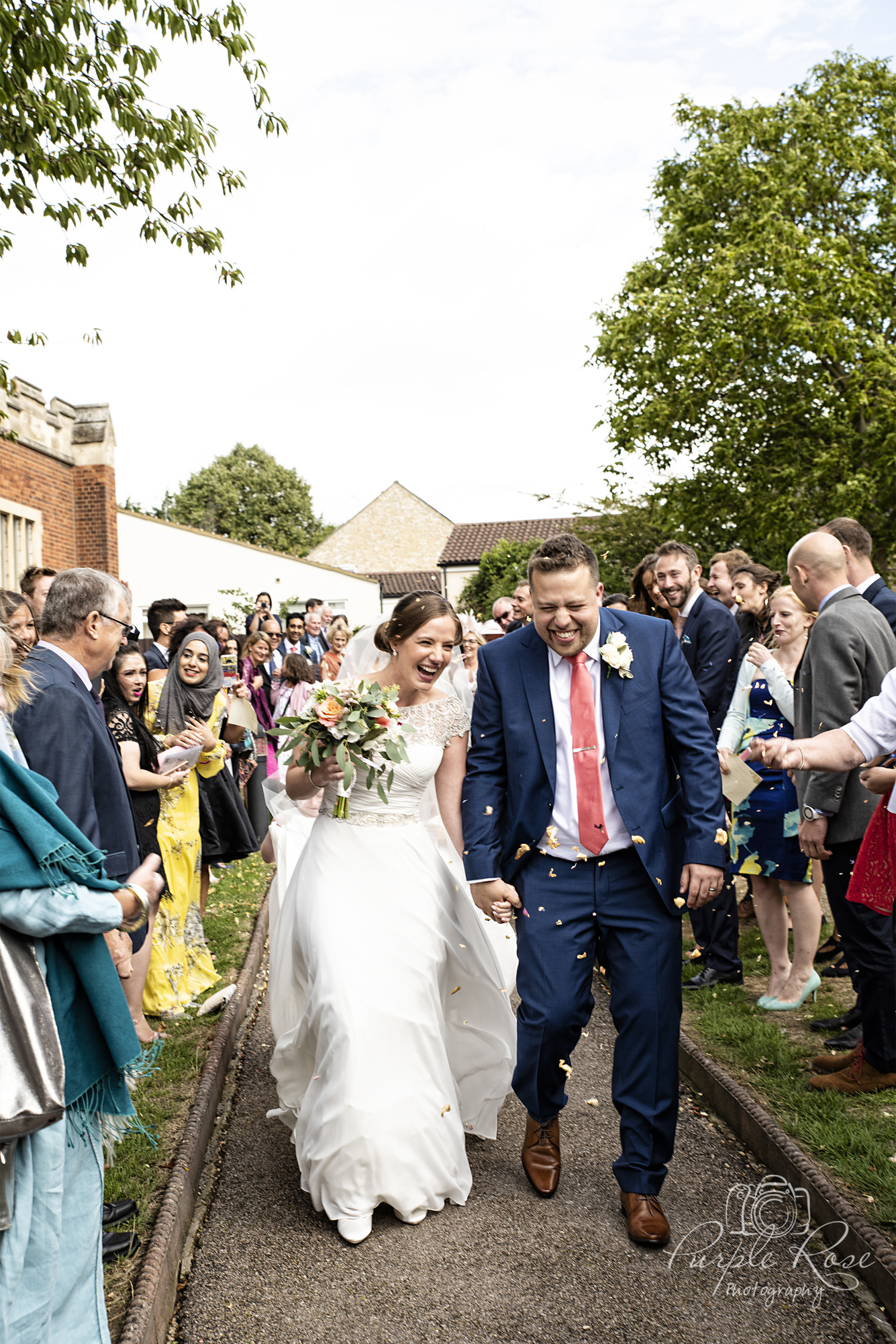 Bride and groom being showered with confetti