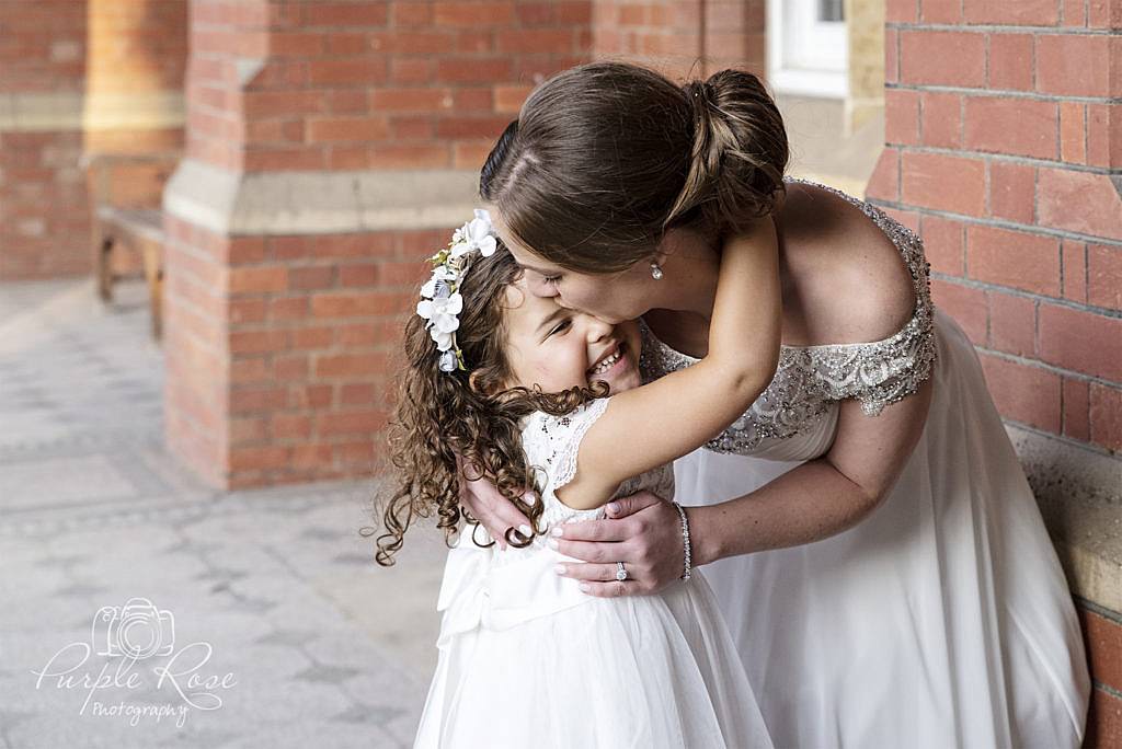 Bride embracing a flower girl