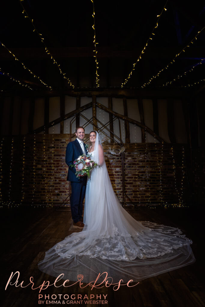 Photo of a bride and groom in a fairy light lit barn on their wedding day in Milton Keynes