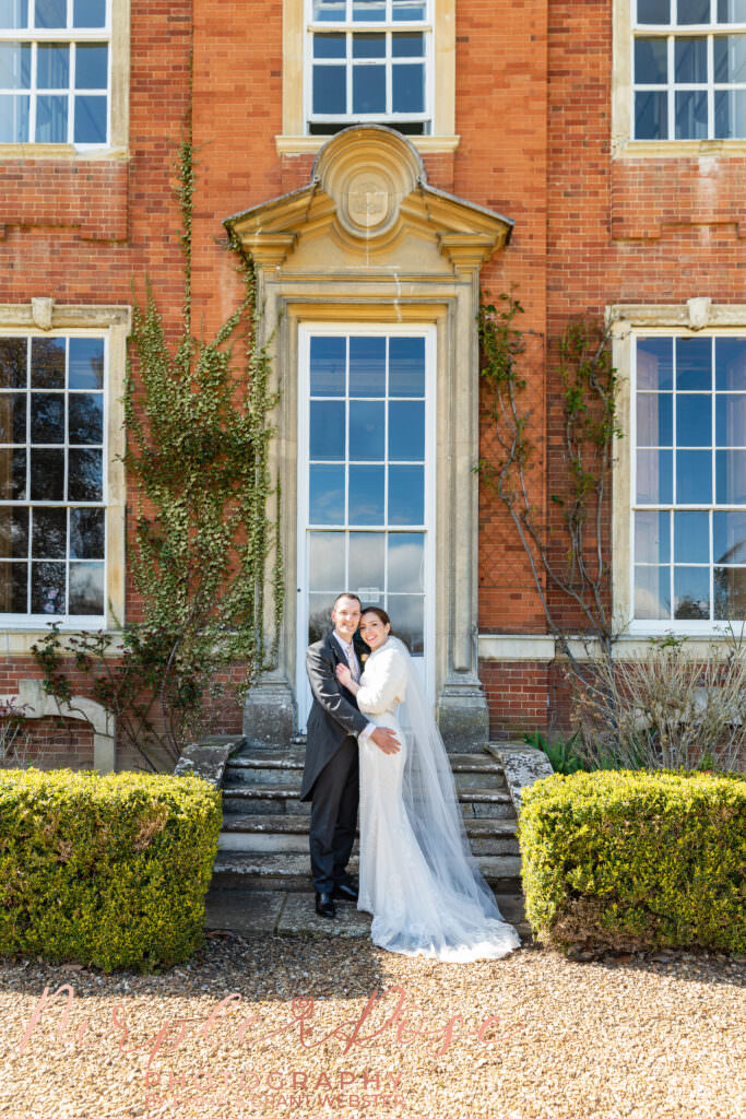 Photo of a bride and groom in fornt of a window on their wedding day in Milton Keynes