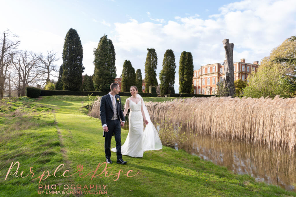 Photo of bride and groom walking hand in hand on their wedding day in Milton Keynes