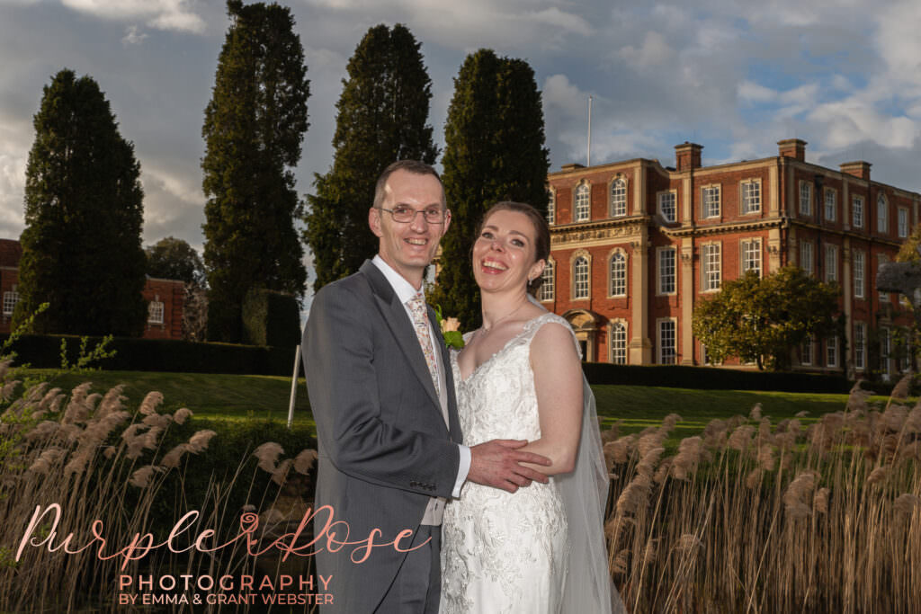 Photo of bride and groom on their wedding day with Chicheley Hall behind them in Milton Keynes