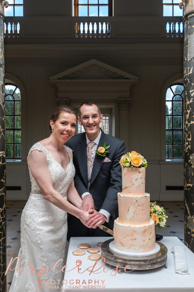 Photo of a bride and groom cutting their wedidng cake on their wedding day in Milton Keynes