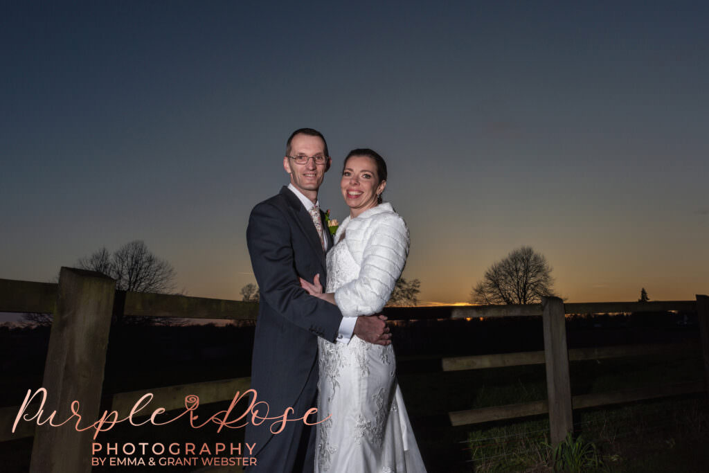 Photograph of bride and groom in front of a sunset on their wedding day in Milton Keynes