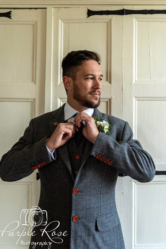 Groom adjusting his tie