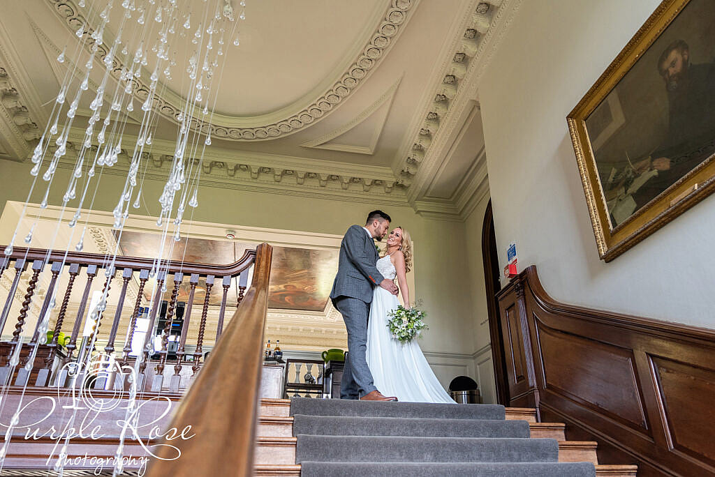 Bride and groom standing at the top of a staircase