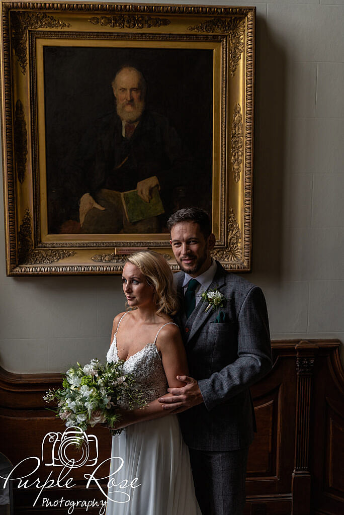 Bride and groom in front of an oil painting