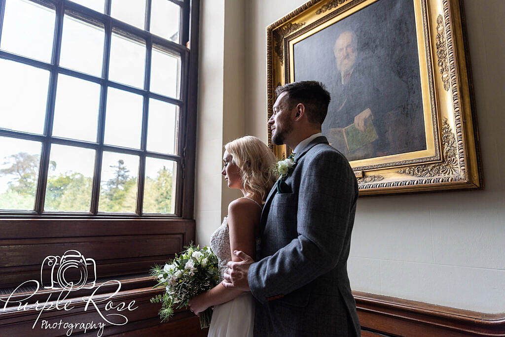 Bride and groom looking out a window