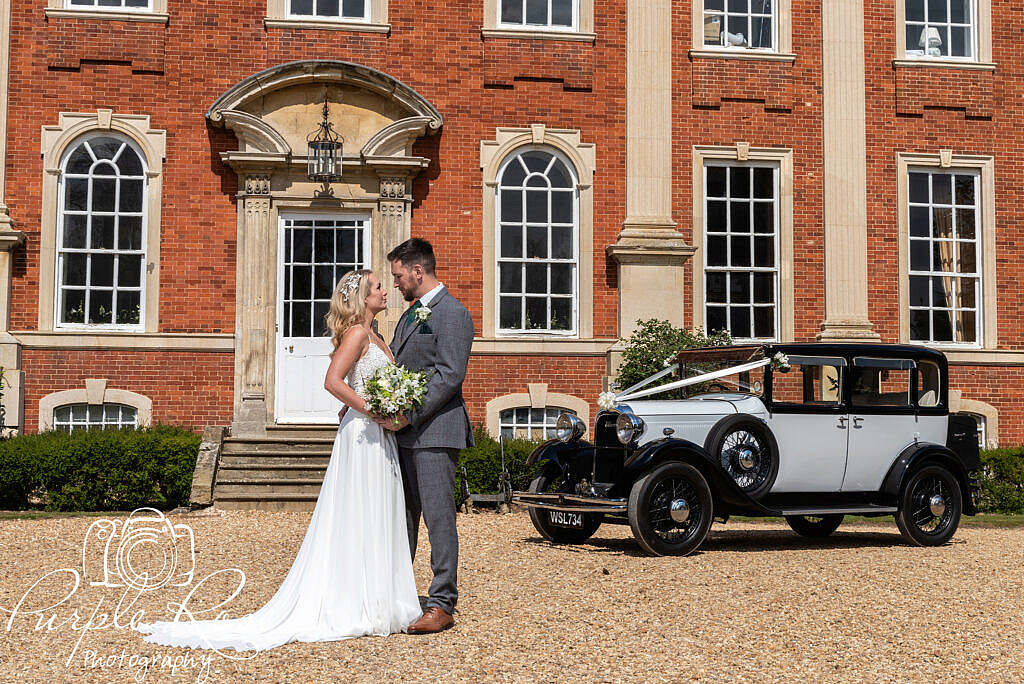 Bride and groom with wedding car and venue