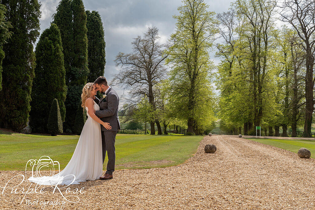 Bride and groom standing on stone pathway