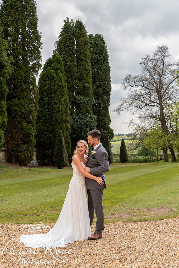 Bride and groom laughing in their venues gardens