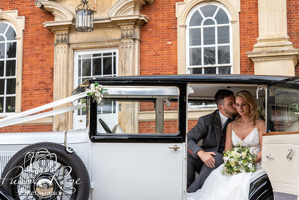 Bride and groom sat in their wedding car