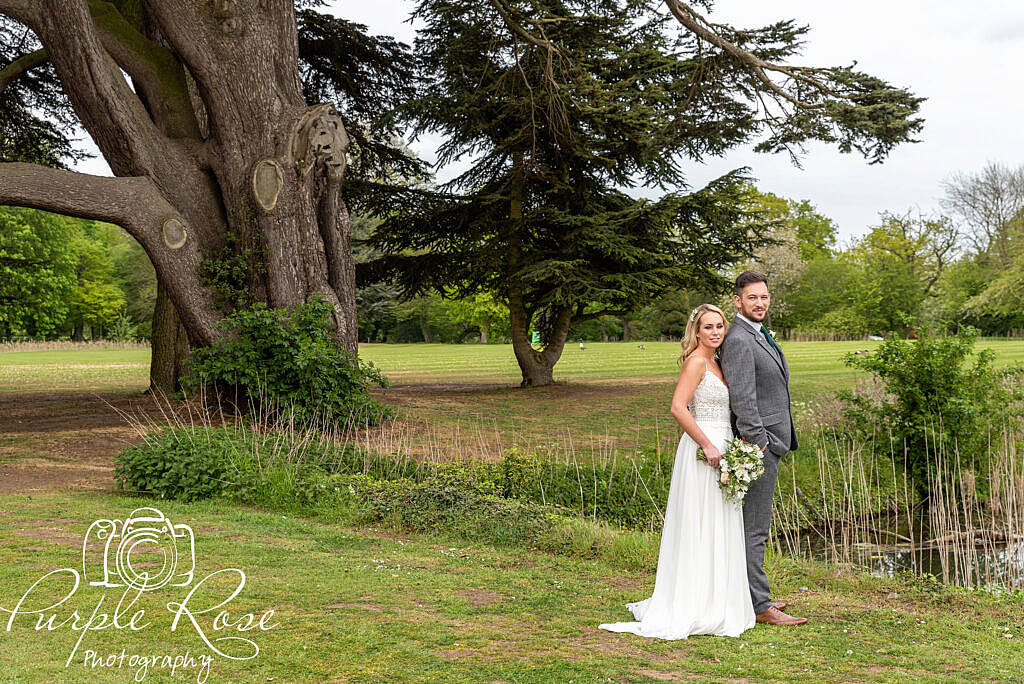 bride and groom by a pond