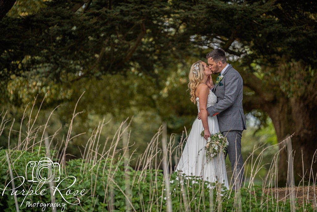 Close up of bride and groom by a pond