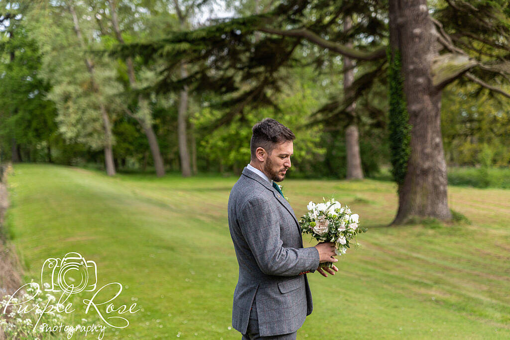 Groom holding the brides flowers