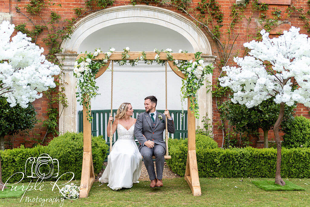 Bride and groom playing on a swing