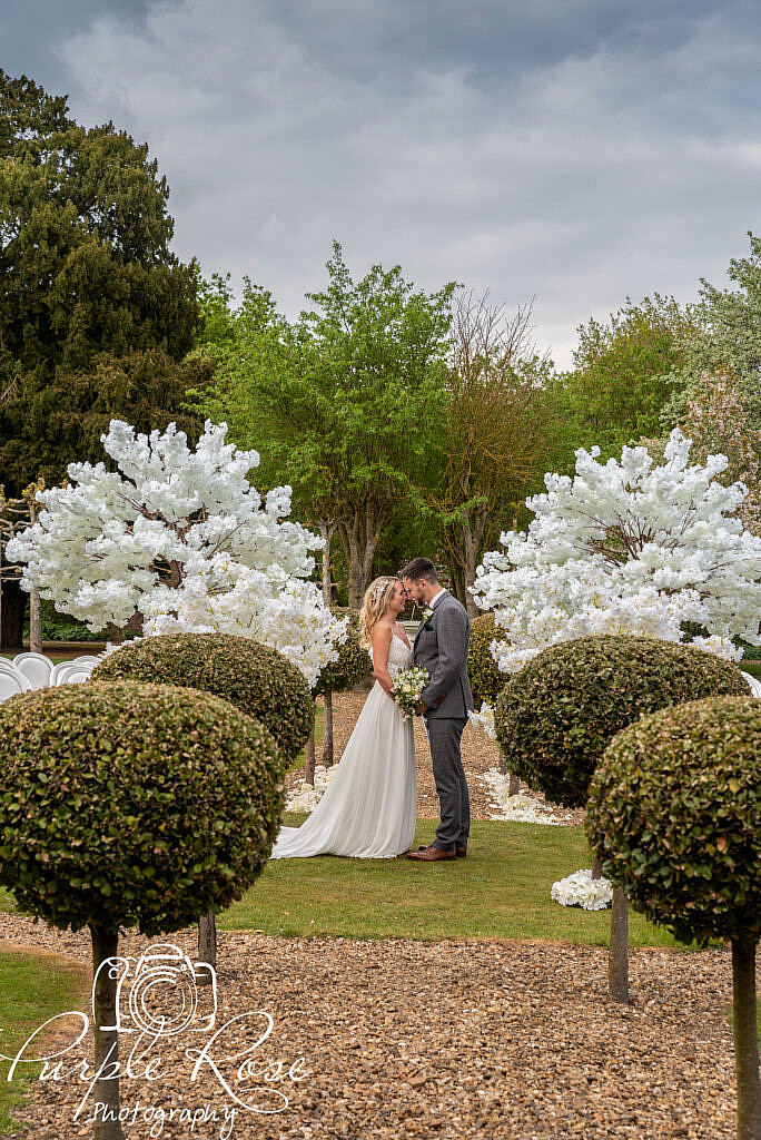 Bride and groom embracing in their venues gardens