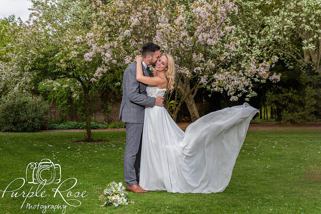 Bride and groom surrounded by cherry blossom trees