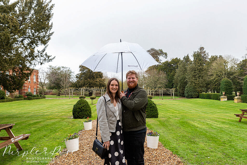 Couple sheltering under an umbrella