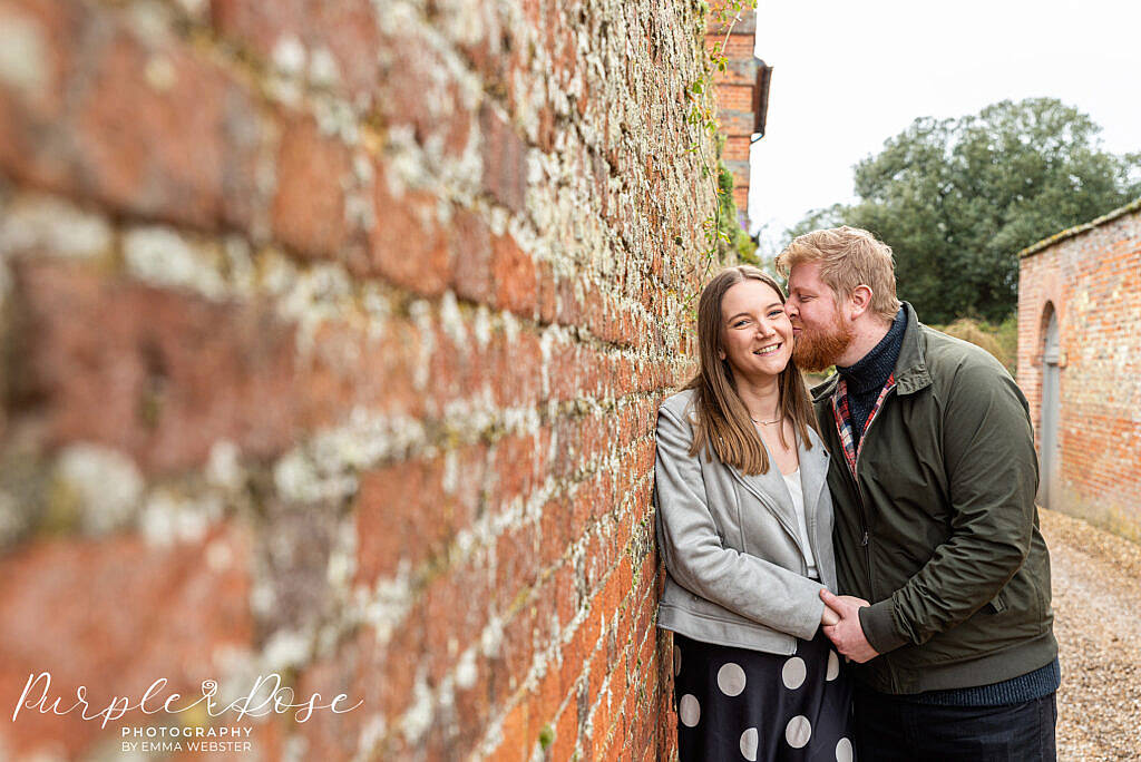 Couple leaning on a brick wall