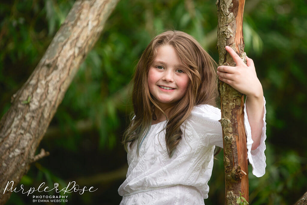 Girl leaning on a tree branch