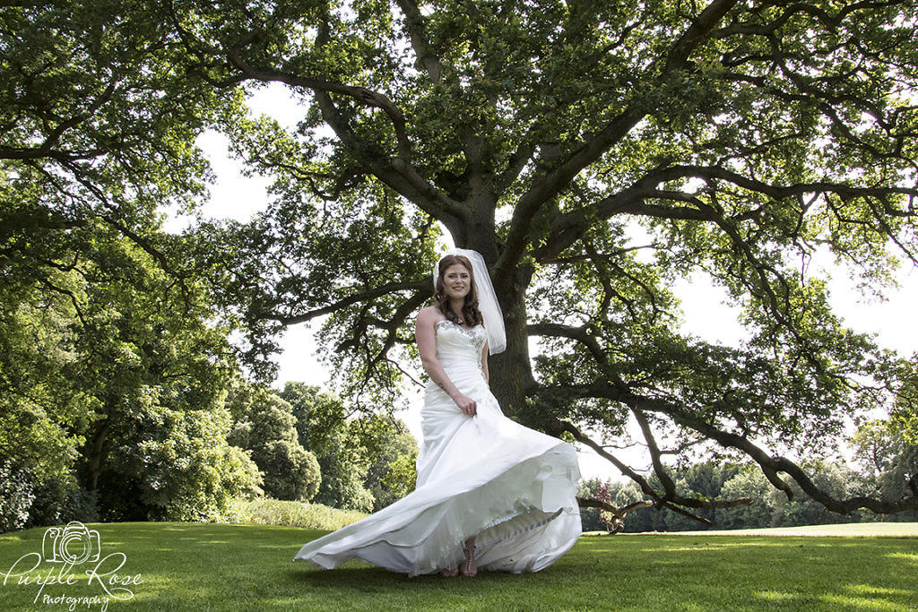 Bride twirling her dress in tree surrounded garden