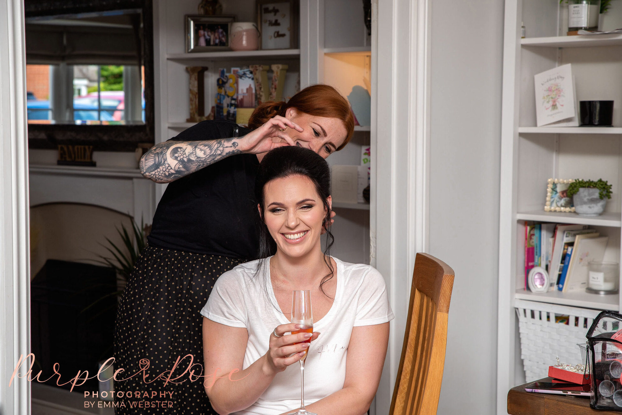 Bride enjoying a drink while her hair is styled