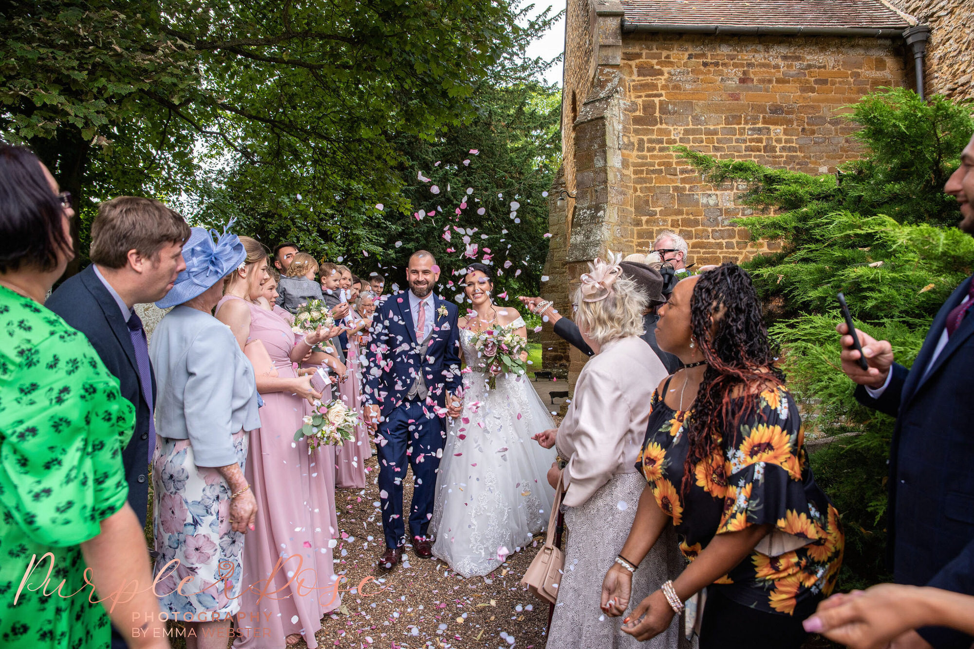 Bride and groom leaving the church as guest throw confetti