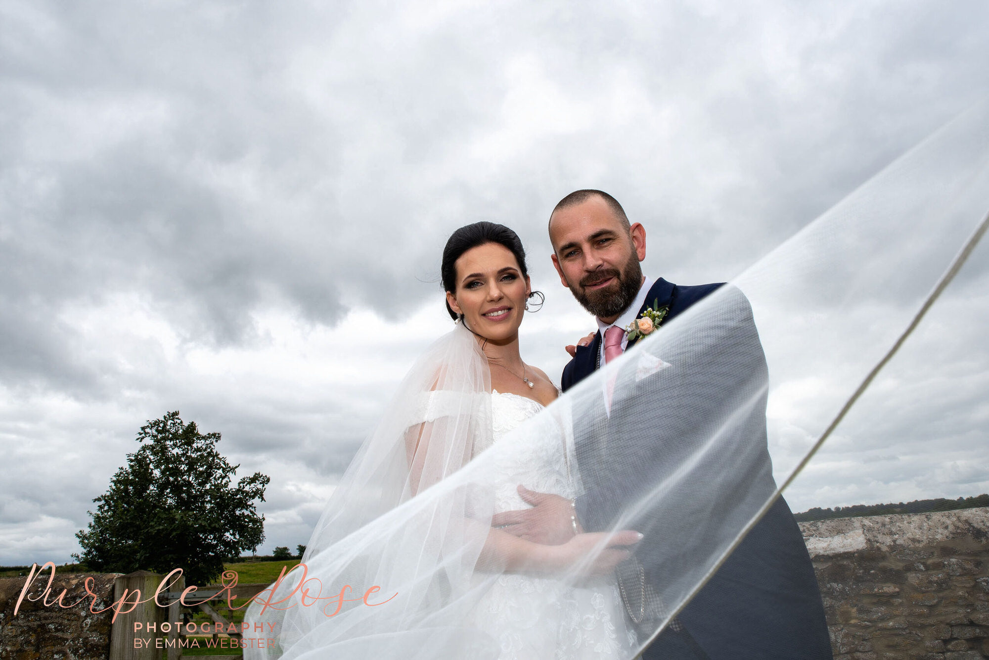 Wedding veiling swirling around bride and groom