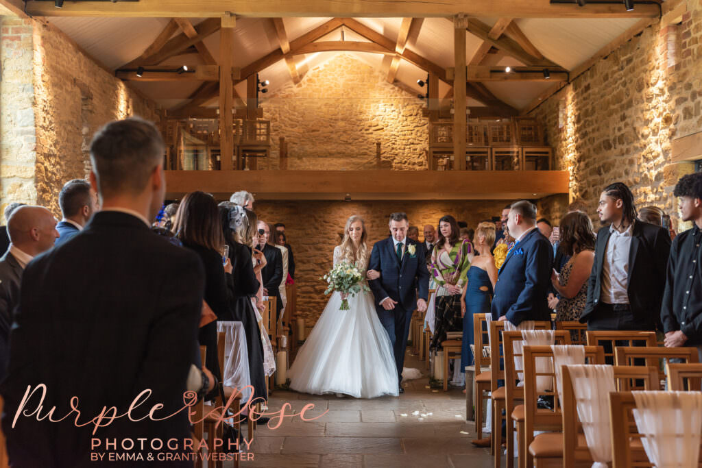 Photo of a bride and father walking to the wedding ceremony in Milton Keynes