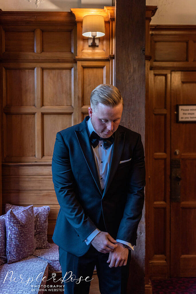 Groom adjusting his shirt sleeves