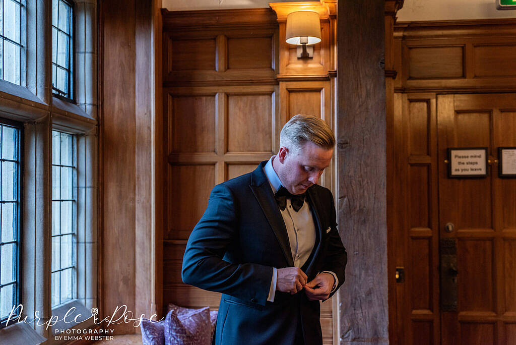 Groom doing up his jacket