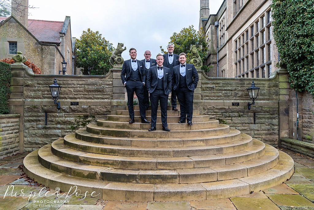 Groom and groomsmen on the steps at their venue