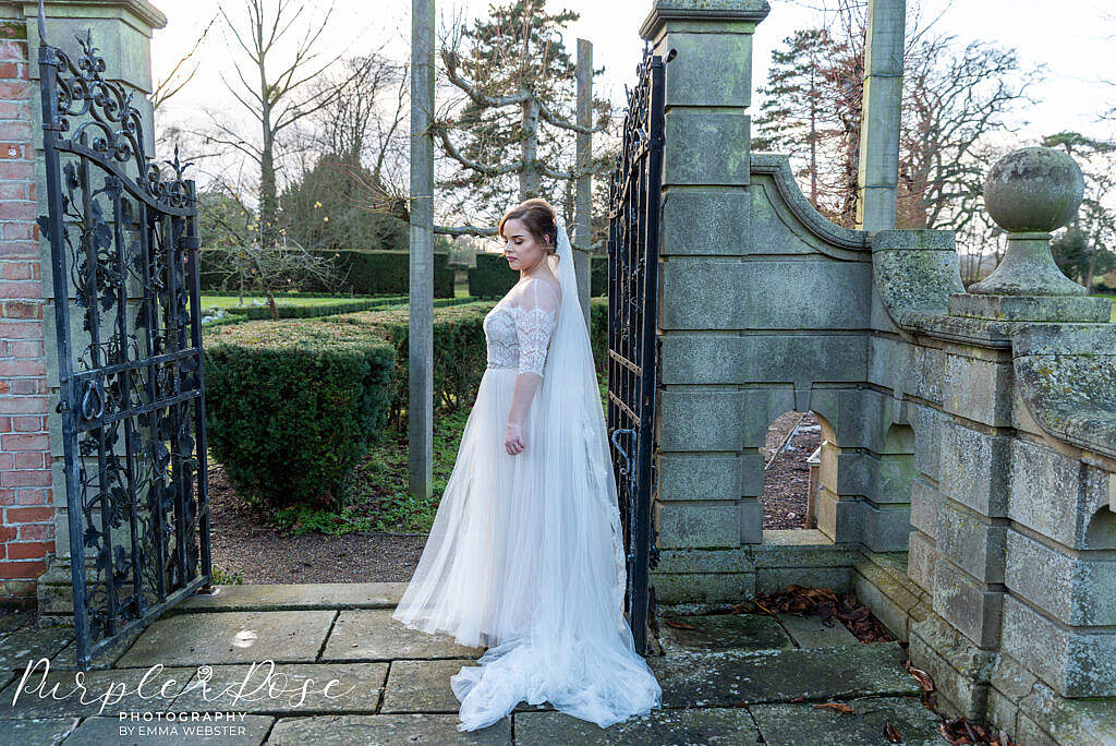 bride waiting by a gate