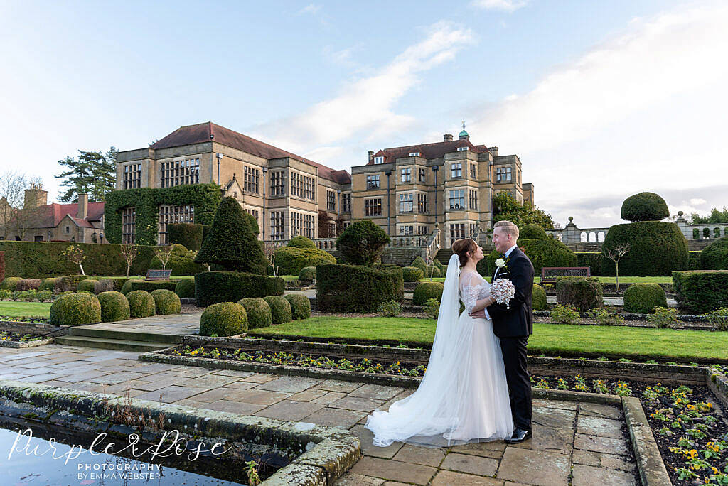 bride and groom stood in front of Farnham Hall