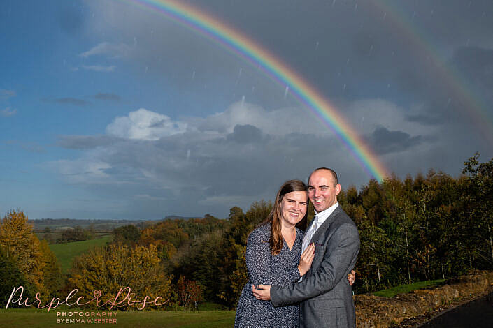 Couple in front of a rainbow