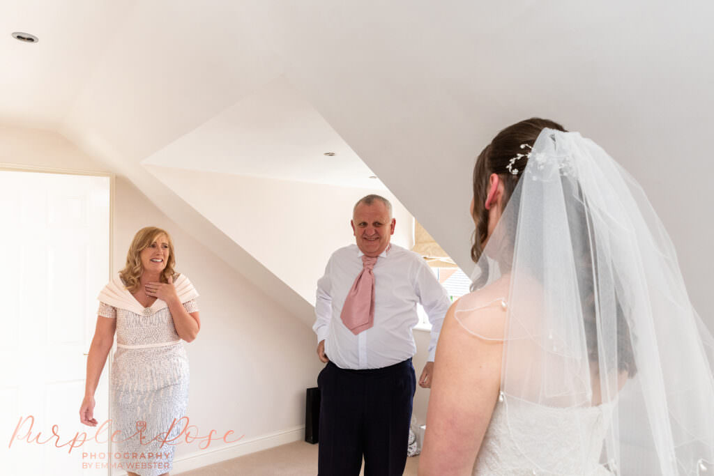 Parents seeing their daughter in her wedding dress