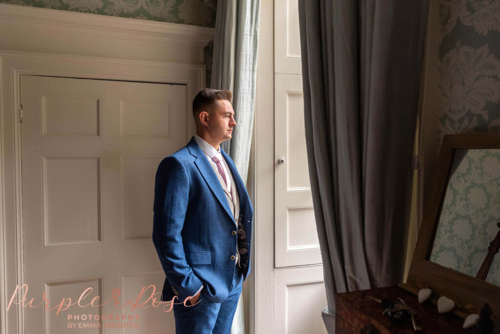 Groom stood in front of window