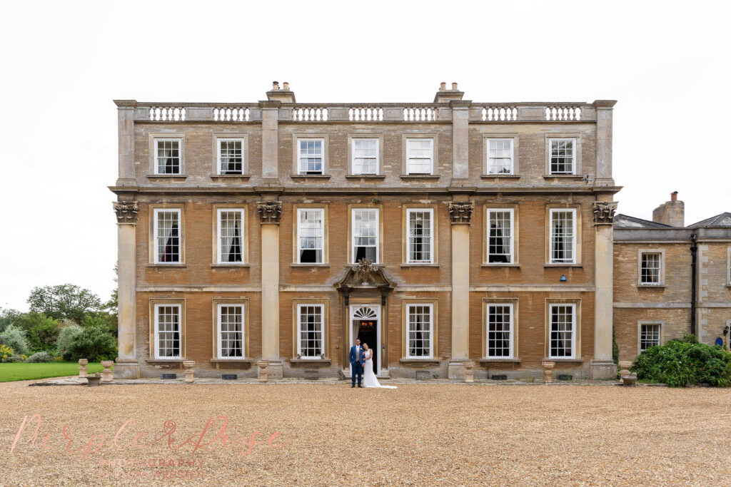 Bride and groom stood in front of Hinwick House