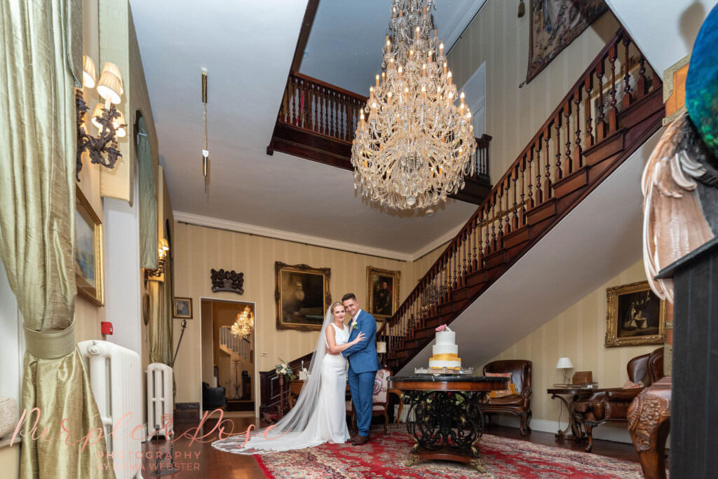 Bride and groom under a chandelier