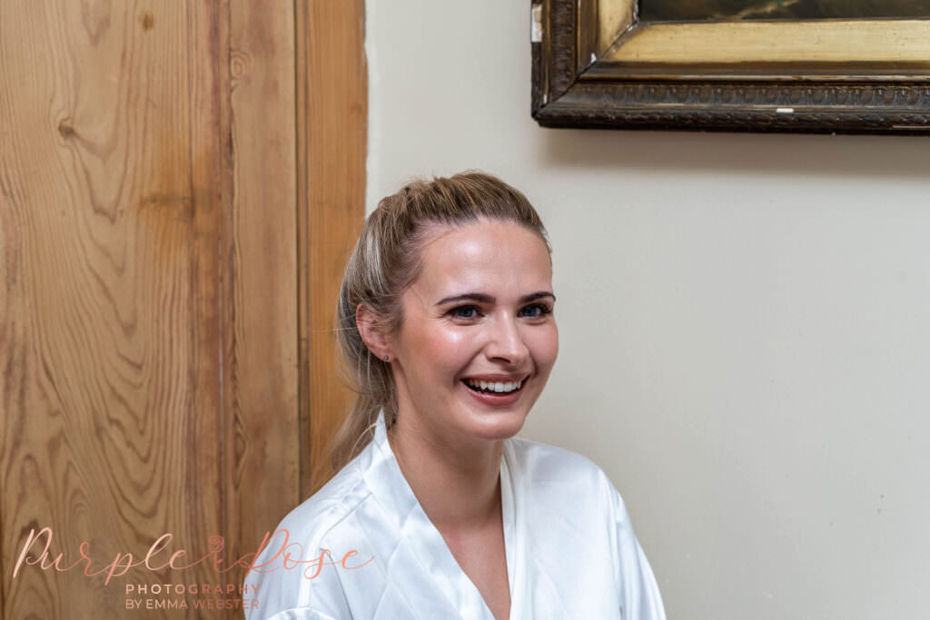 Bride laughing while she gets ready for her wedding