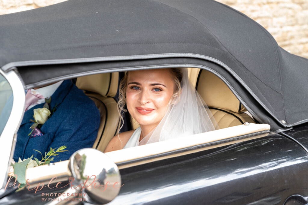 Bride sat in a car looking out the window