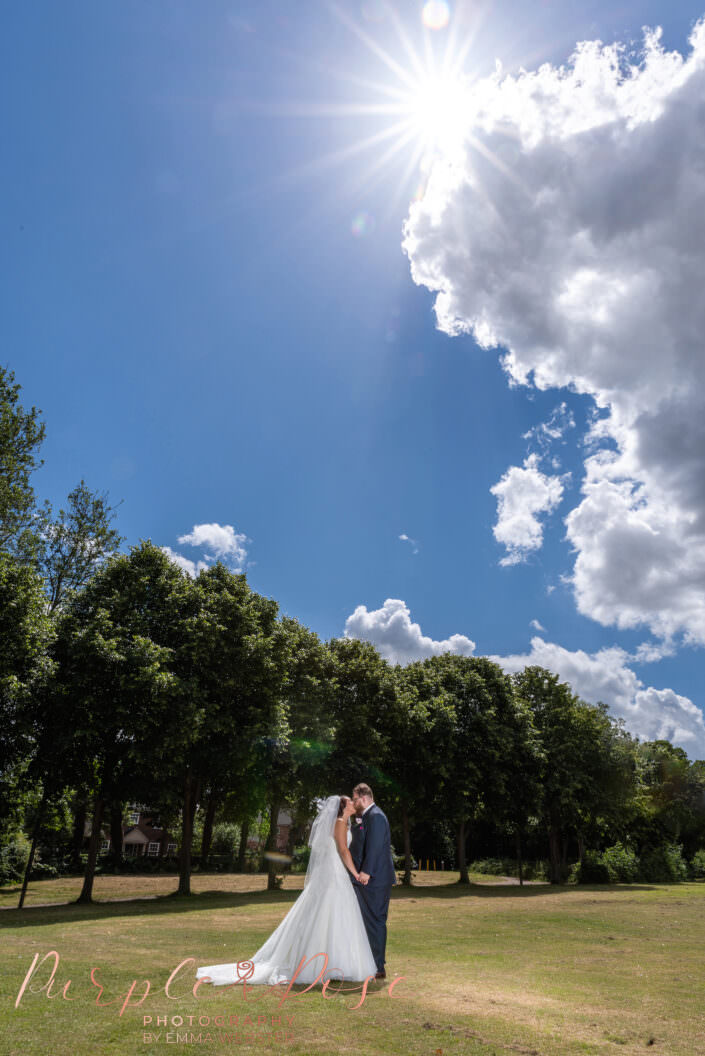 Bride and groom in front of a tree line