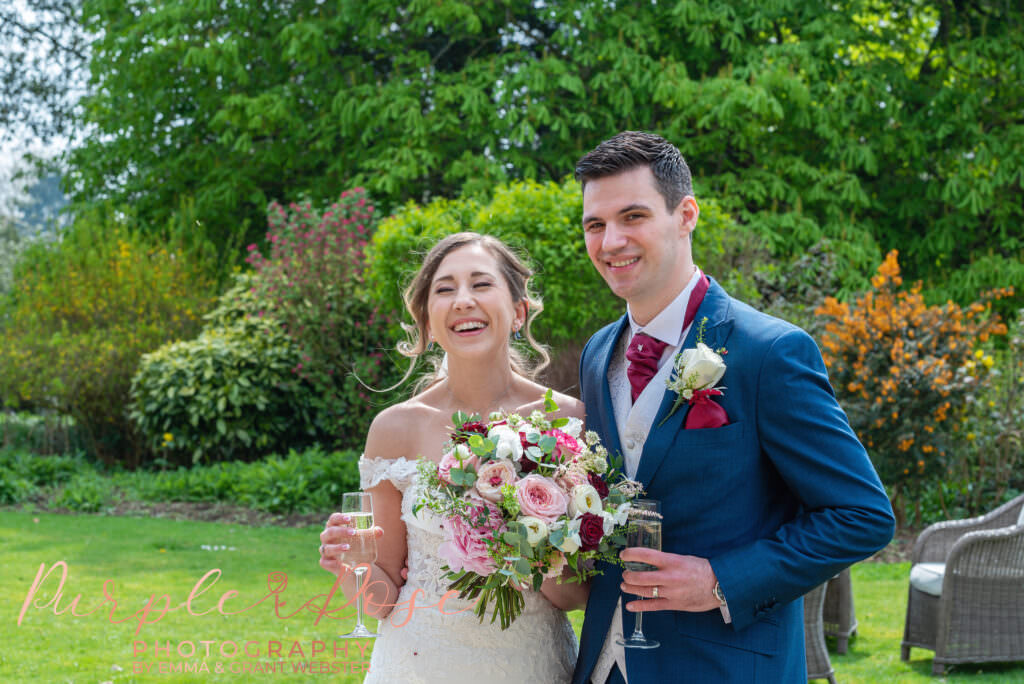 Photo of bride and groom in the gardens of their wedding venue in Milton Keynes laughing