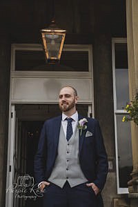 Groom standing in doorway 