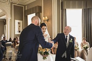 Groom shaking father of the brides hand