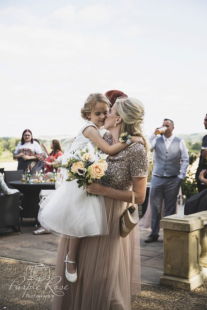 Flower girl hugging her mum